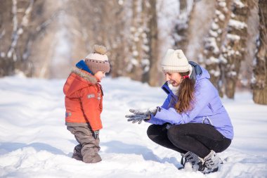 kadın parkta bir kış için küçük bir çocukla yürümek.