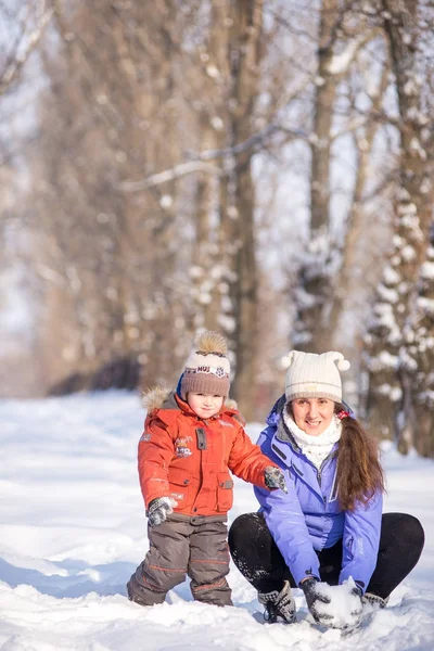 Mujer con un niño pequeño en el parque para una caminata de invierno . — Foto de Stock