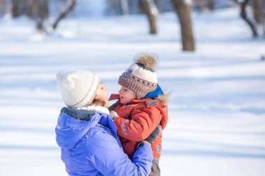 kadın parkta bir kış için küçük bir çocukla yürümek.