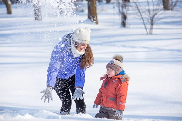 Mujer con un niño pequeño en el parque para una caminata de invierno . — Foto de Stock