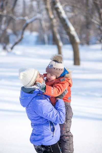 Mujer con un niño pequeño en el parque para una caminata de invierno . — Foto de Stock