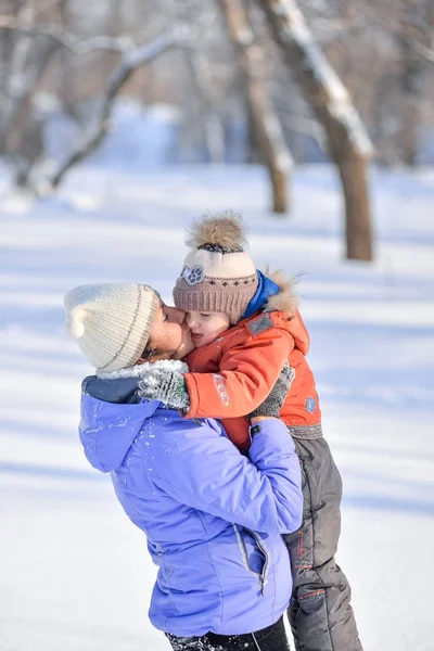 Mulher com uma criança pequena no parque para uma caminhada de inverno . — Fotografia de Stock