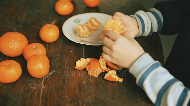 Child Cleans Tangerines Wooden Table — Stock Video