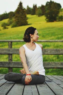 Genç kadının asanas dağlarda yapması