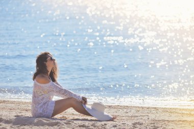 Yaz aylarında sahilde oturan genç kadın