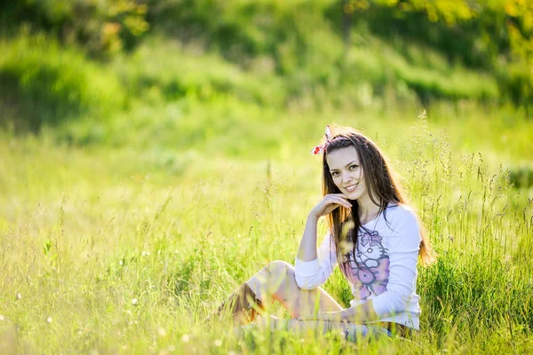 Bella ragazza è seduta sull'erba in giardino — Foto Stock