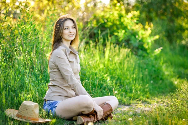 Bella ragazza è seduta sull'erba in giardino — Foto Stock