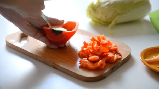 Eine Frau Schneidet Mit Einem Messer Eine Paprika Auf Einem — Stockvideo