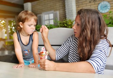 dondurma bir kafede ile küçük bir oğlu anne beslemeleri