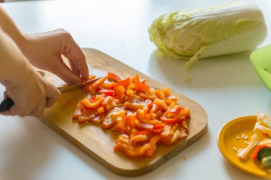 Bir kadın bir vejetaryen salata için kırmızı biber kesme.