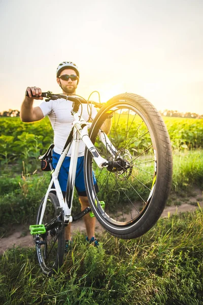 El ciclista masculino elevó su bicicleta a la rueda trasera . — Foto de Stock