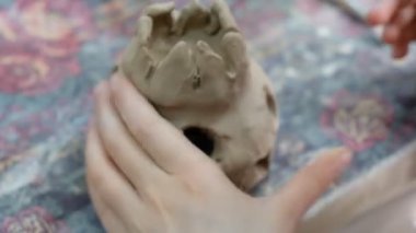 Çocuk seramik atölyede farklı türde kil ürünleri şekillendirmeyi öğreniyor. Çocuk, yaratıcı bir derste kilden bağımsız olarak çalışır..