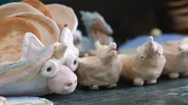 Çocuk seramik atölyede farklı türde kil ürünleri şekillendirmeyi öğreniyor. Çocuk, yaratıcı bir derste kilden bağımsız olarak çalışır..