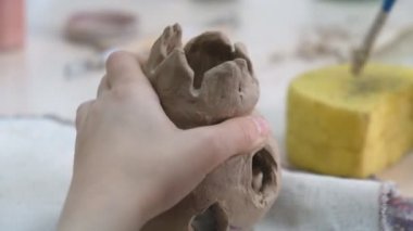 Çocuk seramik atölyede farklı türde kil ürünleri şekillendirmeyi öğreniyor. Çocuk, yaratıcı bir derste kilden bağımsız olarak çalışır..