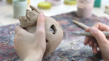 Çocuk seramik atölyede farklı türde kil ürünleri şekillendirmeyi öğreniyor. Çocuk, yaratıcı bir derste kilden bağımsız olarak çalışır..