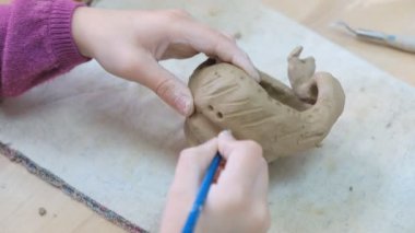 Çocuk seramik atölyede farklı türde kil ürünleri şekillendirmeyi öğreniyor. Çocuk, yaratıcı bir derste kilden bağımsız olarak çalışır..