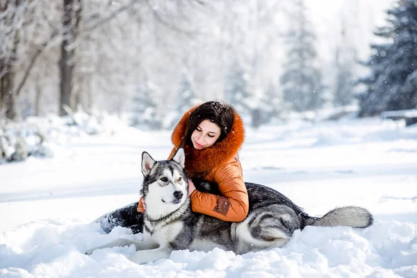 Mädchen spielt im Winter mit Hund im Park. — Stockfoto