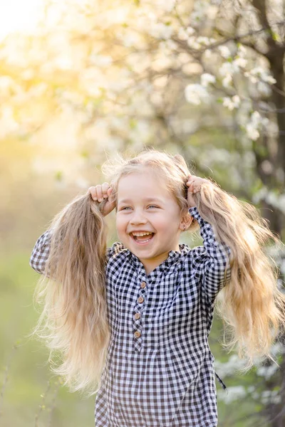 Piccola ragazza bionda che si diverte nel parco primaverile. — Foto Stock