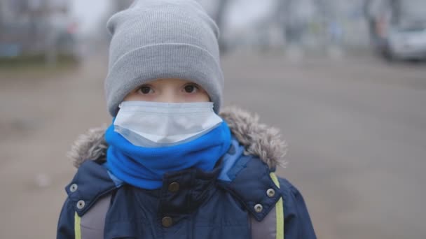 Китайський коронавірус в Європі. Епідемія в Європі. Маленький хлопчик захищає себе від коронавірусу в медичній масці в громадському місці.. — стокове відео