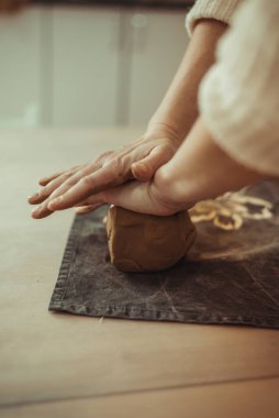 Bir adam elleriyle kil kırıştırır. Çömlek çarkı üzerinde çalış. Usta kil hazırlıyor..