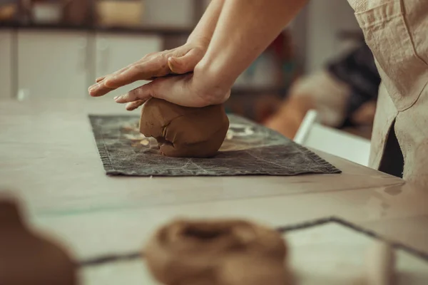 Ein Mann faltet Ton mit den Händen. Arbeiten an der Töpferscheibe. Der Meister bereitet Lehm vor. — Stockfoto