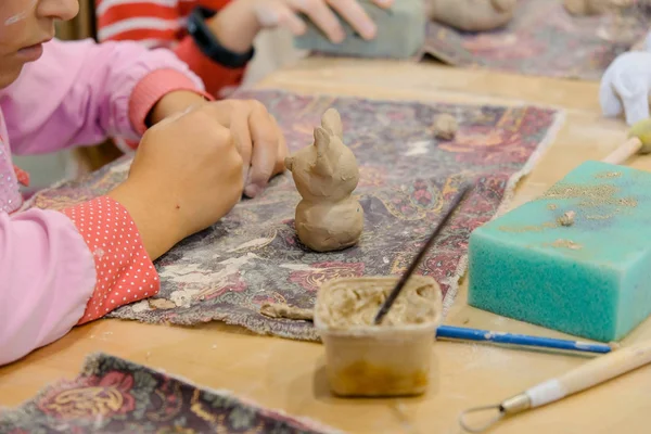 Uma criança molda um produto de argila em uma lição de modelagem. — Fotografia de Stock