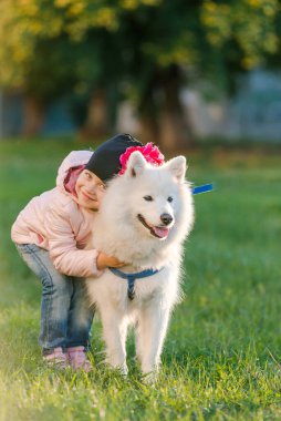 küçük kız köpeğini Samoyed Park ile yürüyor
