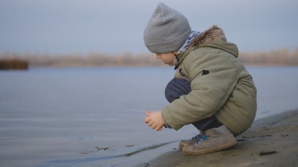 Um menino caminha perto do rio na queda. — Vídeo de Stock