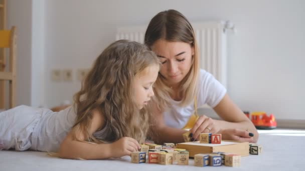 Mladá matka učí dceru abecedu. — Stock video