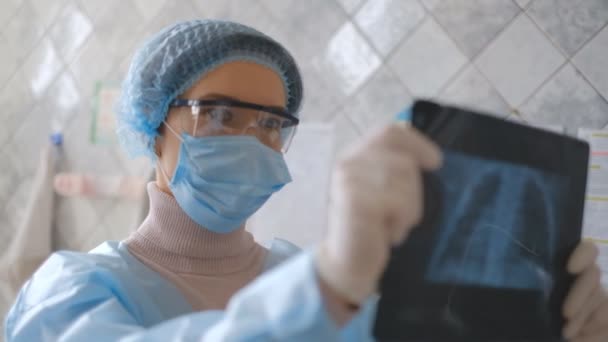 Egy orvos egy coronavirus betegségben szenvedő beteg fluorográfiás vizsgálatát vizsgálja.. — Stock videók
