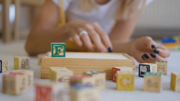 女孩从立方体收集这个词 概念视频 用木制立方体和字母拼成的字 — 图库视频影像