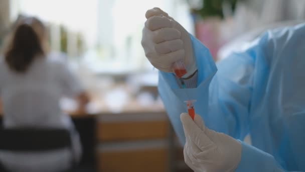 Un médico científico introduce una porción de una vacuna contra el coronavirus en una jeringa . — Vídeo de stock