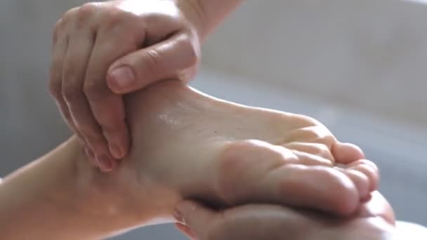 Профессиональный массажист делает массаж ног молодой женщине . — стоковое видео