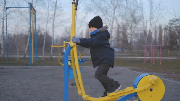 Little Boy Goes Sports Simulator Outdoors — Stock Video