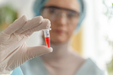 Bilim adamı doktor laboratuvarda koronavirüs Sars-Cov-2 'ye karşı bir aşı geliştirdi. Doktor elinde yeni bir aşı şişesi tutuyor..