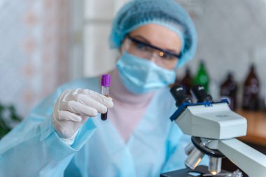 Bilim adamı doktor laboratuvarda koronavirüs Sars-Cov-2 'ye karşı bir aşı geliştirdi. Doktor elinde yeni bir aşı şişesi tutuyor..