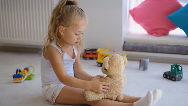 Küçük Bir Kız Oyuncak Ayısıyla Doktorculuk Oynuyor Küçük Sarışın Evde — Stok video
