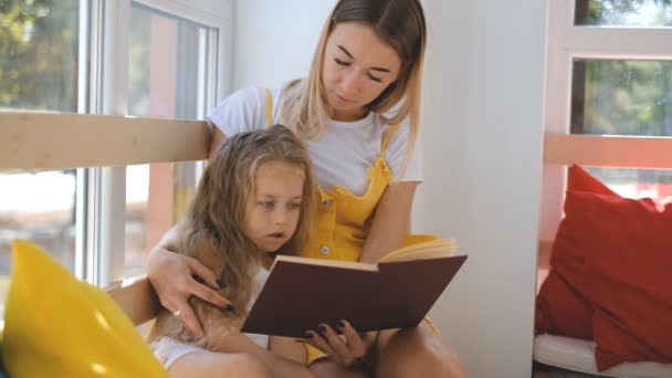 Una Madre Joven Una Hija Pequeña Están Leyendo Libro Juntas — Vídeos de Stock
