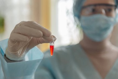 Bilim adamı doktor laboratuvarda koronavirüs Sars-Cov-2 'ye karşı bir aşı geliştirdi. Doktor elinde yeni bir aşı şişesi tutuyor..