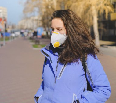 Koruyucu tıbbi maskeli bir adam Almanya 'da bir caddede duruyor. Almanya 'da koronavirüs salgını.