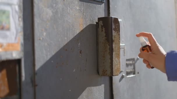 Desinfecção do punho e fechamento da porta para a casa com uma solução de álcool . — Vídeo de Stock
