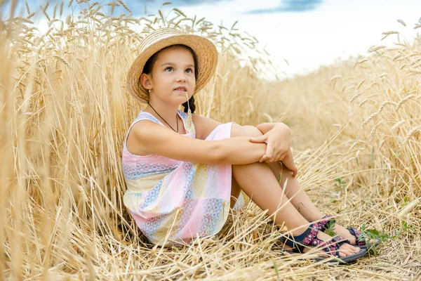 Uma Menina Senta Campo Trigo Chapéu Palha Verão — Fotografia de Stock