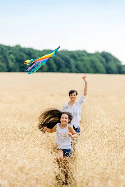 Moeder Dochter Rennen Een Tarweveld Met Een Vlieger Zomer Gelukkige — Stockfoto