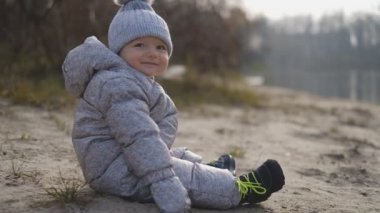 Çocuk baharda nehirde oturur. Nehrin yanındaki baharda küçük bir çocukla yürü..