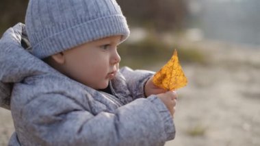 Çocuk baharda nehirde oturur. Nehrin yanındaki baharda küçük bir çocukla yürü..