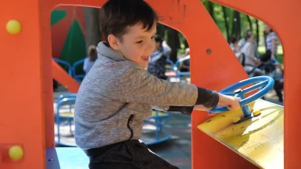 A little boy plays in the playground after the pandemic of the coronavirus COVID-19. — Stock Video