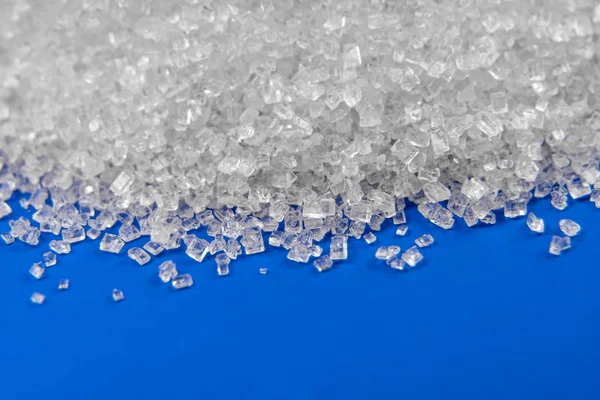 Mavi arka planda beyaz şeker kristalleri