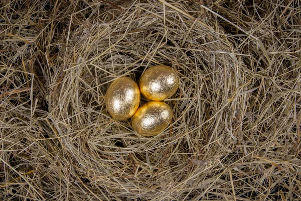 Golden eggs with in a nest top view. Concept easter.