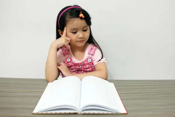 Sevimli küçük Asya kız bir kitap okuma