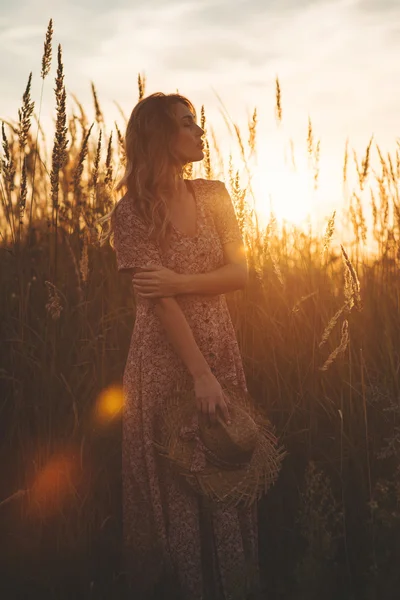 Mooie vrouw in veld bij zonsondergang zomer — Stockfoto